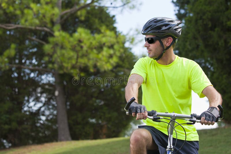 Un giovane di corse in bicicletta all'aperto in una calda giornata d'estate.