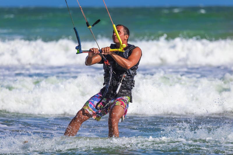 Young atletic man riding kite surf on a sea