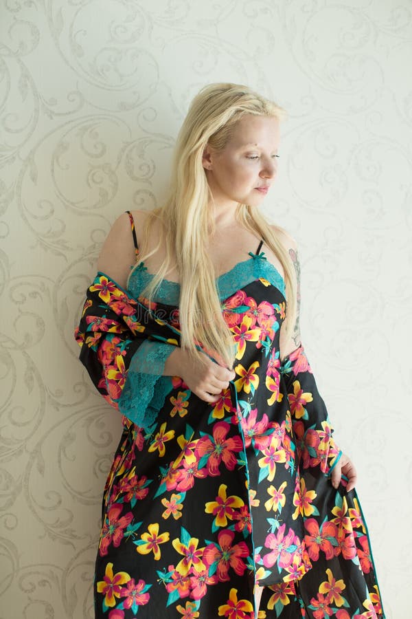 Young Attractive Blonde in a Bright Nightgown and Bright Robe with