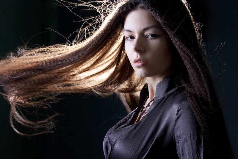 Young attractive brunette woman in dark. Beautiful young witch image for Halloween stock photo Young attractive brunette woman in dark. Beautiful young witch image for Halloween stock photo