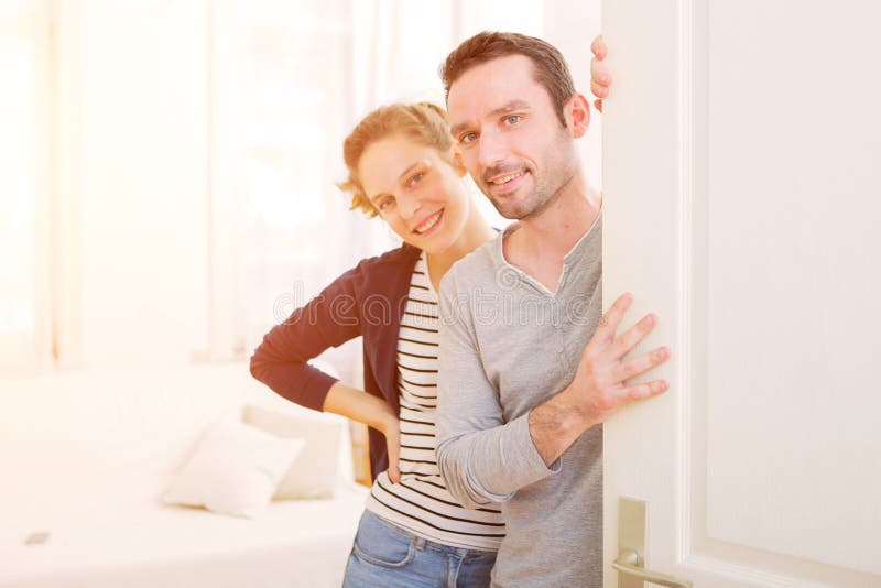 Young attractive couple welcoming you in his house stock photo Young attractive couple welcoming you in his house stock photo