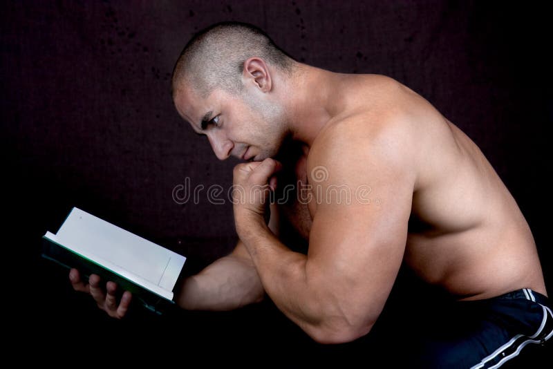 Young attractive male bodybuilder reading the book