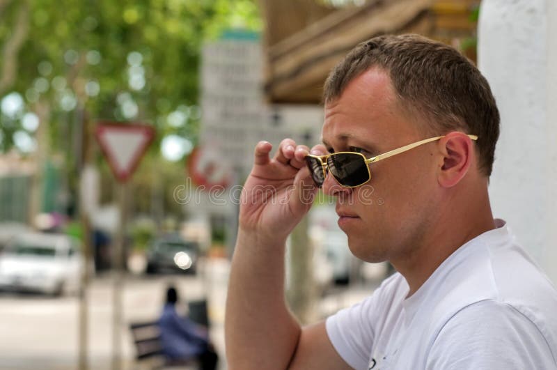 Young attractive man in glasses stands on the street staring intently royalty free stock photo Young attractive man in glasses stands on the street staring intently royalty free stock photo