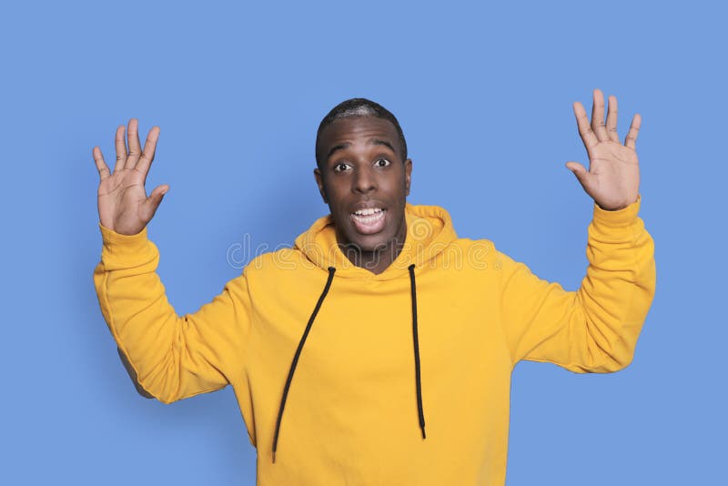 A young attractive man looking surprised isolated on blue background stock images