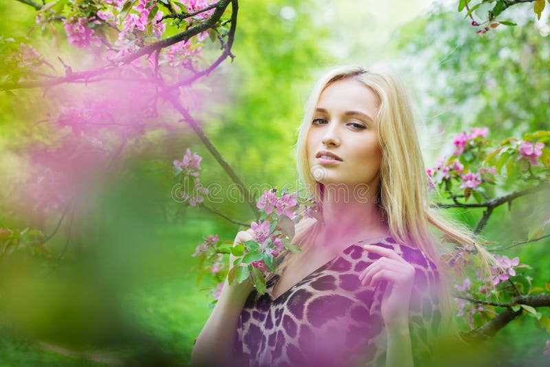 Young attractive woman in blooming spring trees