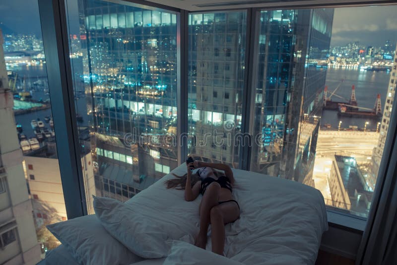 Young attractive woman making self portrait in the bed in the evening