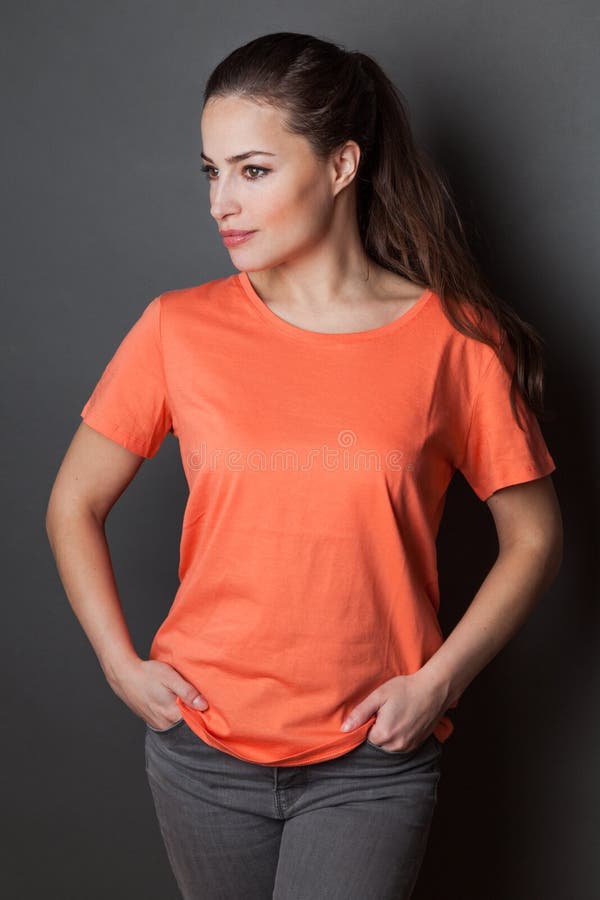 Young attractive woman in orange  t-shirt  studio shot gray background,  t shirt mock up stock image