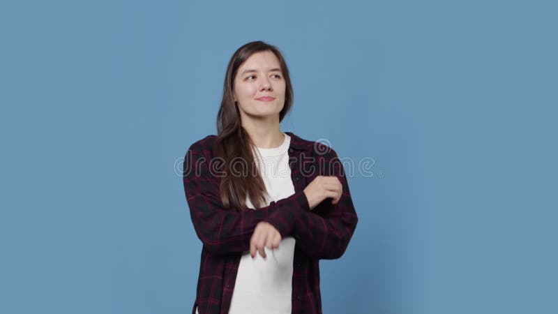 Young attractive woman smiling dreamy and contentedly, crossing her hands on her chest and then looking at the camera on