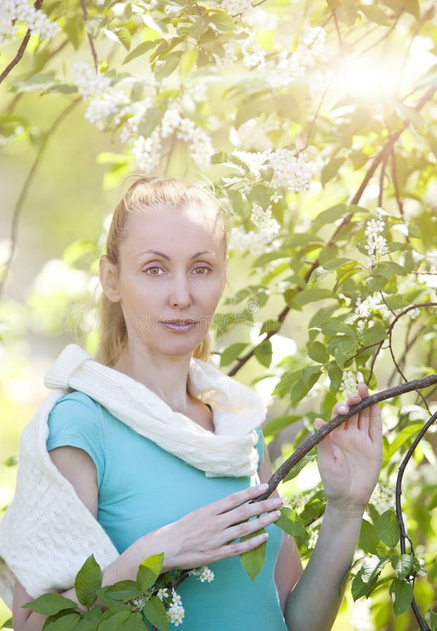 Young Attractive Woman Standing Near The Blossoming Apple Tree Stock