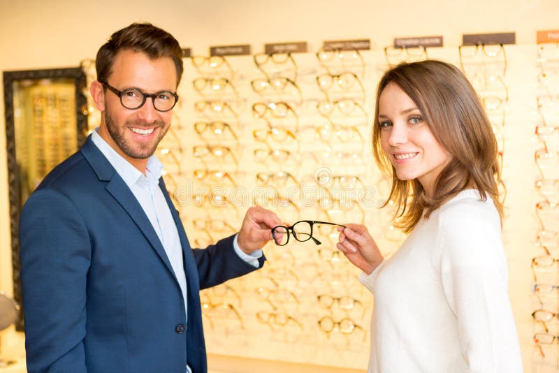 Young attractive woman testing new glasses with optician