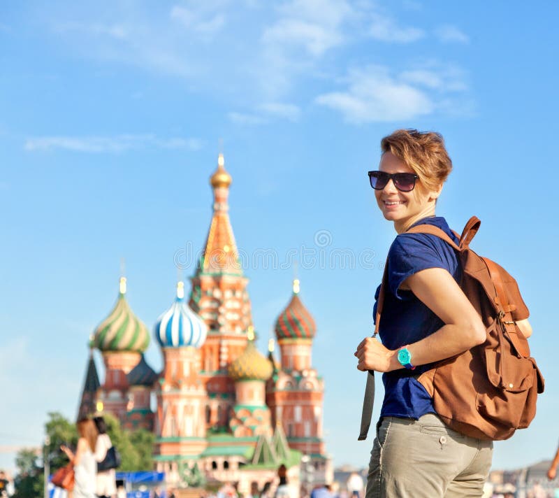 Young attractive woman traveler with backpack on the background