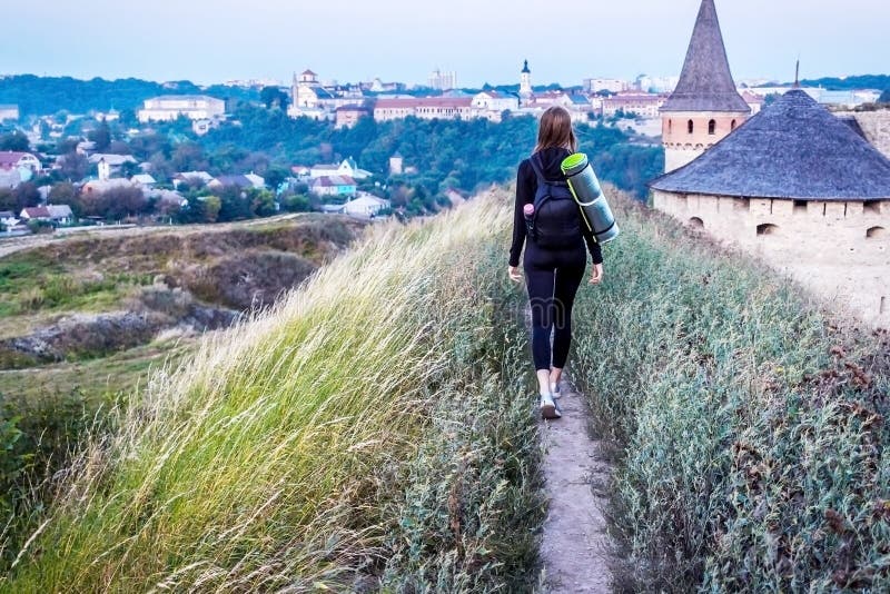 Girl tourist walking along the path to the city