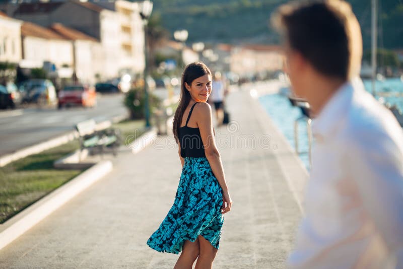 Young attractive woman flirting with a man on the street.Flirty smiling woman looking back on a handsome man.Female attraction