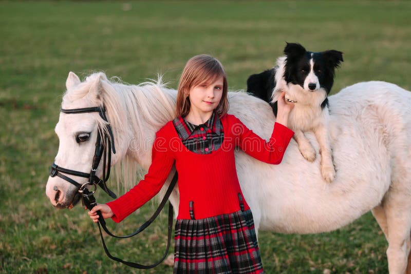 Young baby girl. Red dress. Dog on horseback. Little White Horse pony