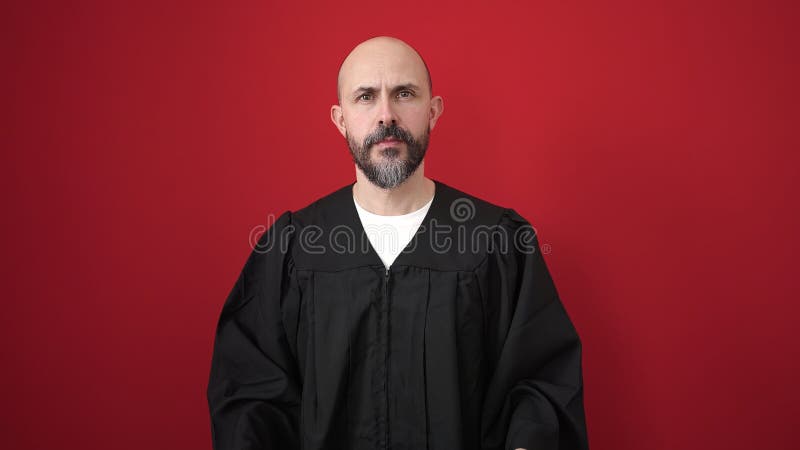 Young bald man wearing costume standing over isolated red background royalty free stock images