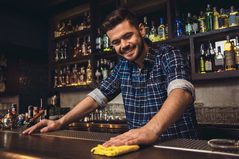 Young Bartender Standing at Bar Counter Cleaning Table Joyful Stock ...