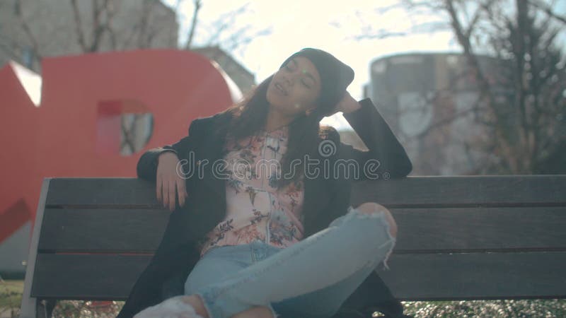 Young beautiful african american woman sitting on a bench.