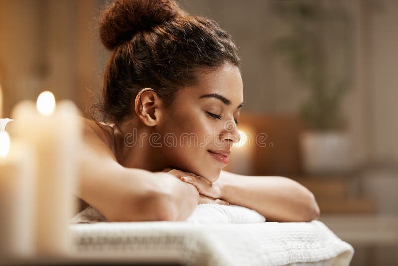 Beautiful african girl resting relaxing in spa resort with closed eyes.