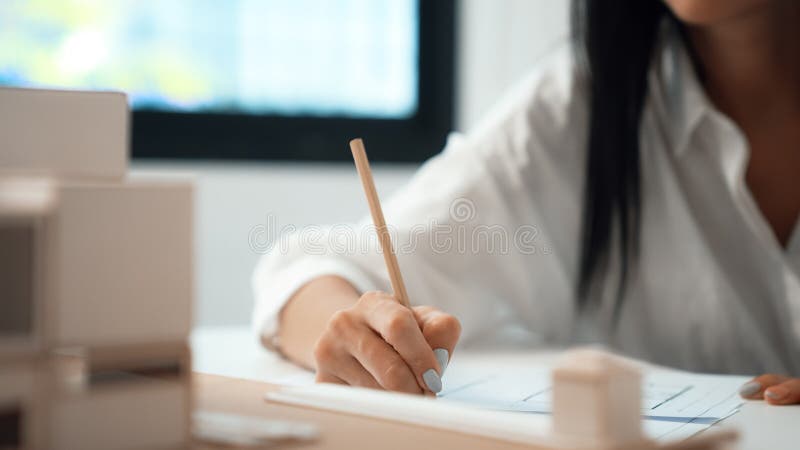 Young beautiful architect hand drawing blueprint at modern office. Immaculate. stock image