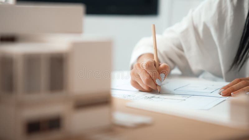Young beautiful architect hand drawing blueprint at modern office. Immaculate. royalty free stock image