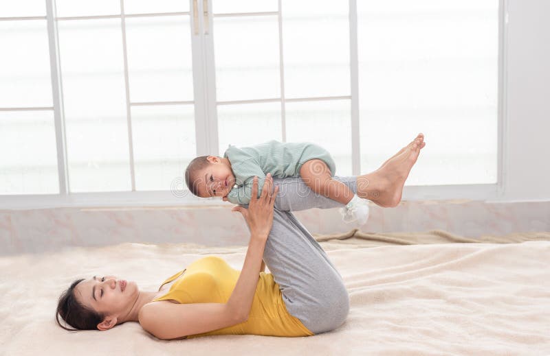 Young Beautiful Asian Mother Exercise Yoga with Little Baby Girl