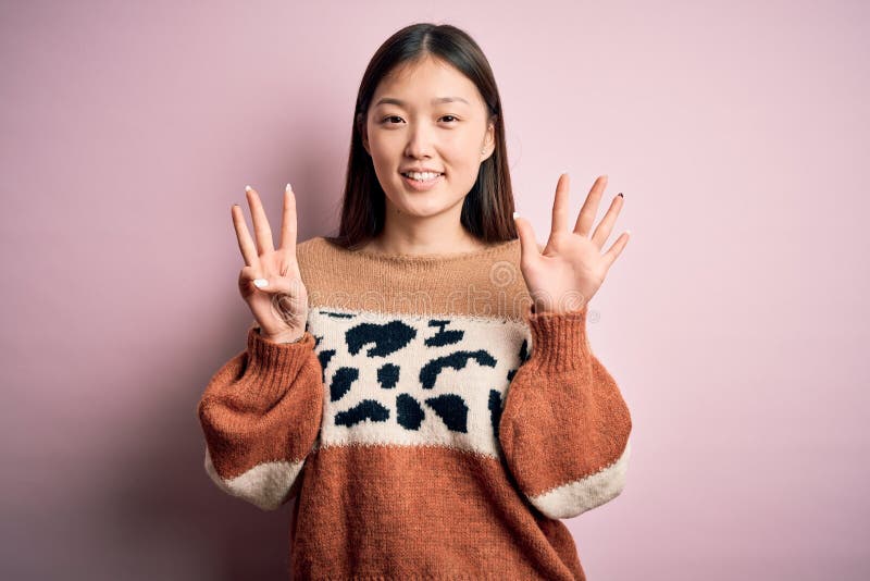 Young beautiful asian woman wearing animal print fashion sweater over pink isolated background showing and pointing up with