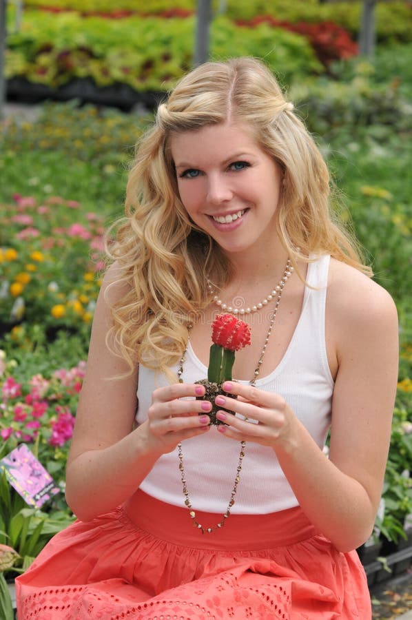 Young beautiful blond holding a cactus