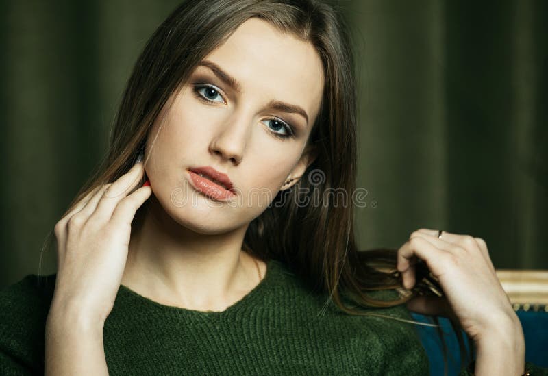 Young beautiful blonde in a green jumper. Close-up portrait.