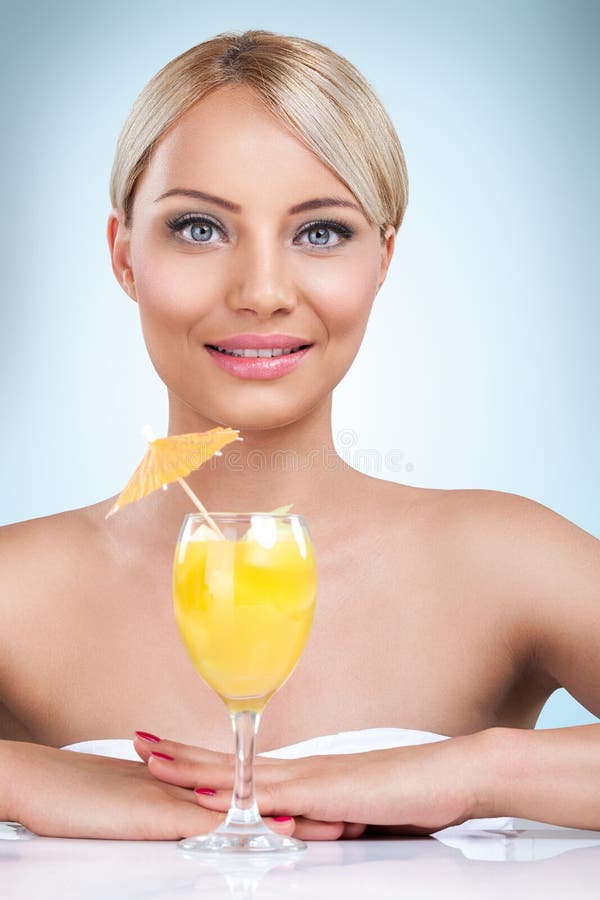 Young beautiful blonde woman drinking cocktail