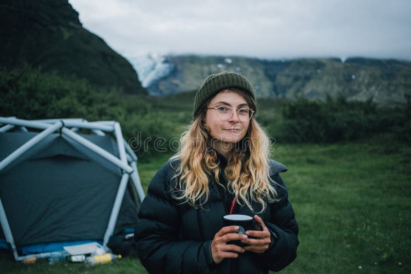 Young woman in down jacket in mountain camping stock images Young woman in down jacket in mountain camping stock images