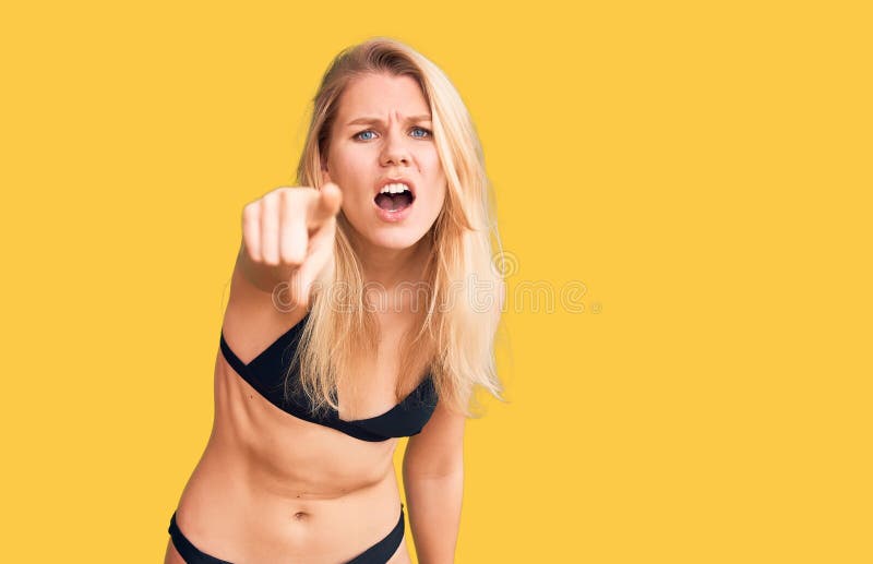 Young beautiful blonde woman wearing bikini pointing displeased and frustrated to the camera, angry and furious with you