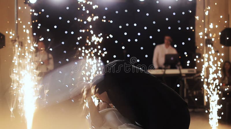 Young beautiful bride and groom dancing first dance at the wedding party shrouded by confetti. Feel happy
