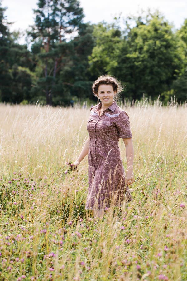 Young woman in country style dress in the field