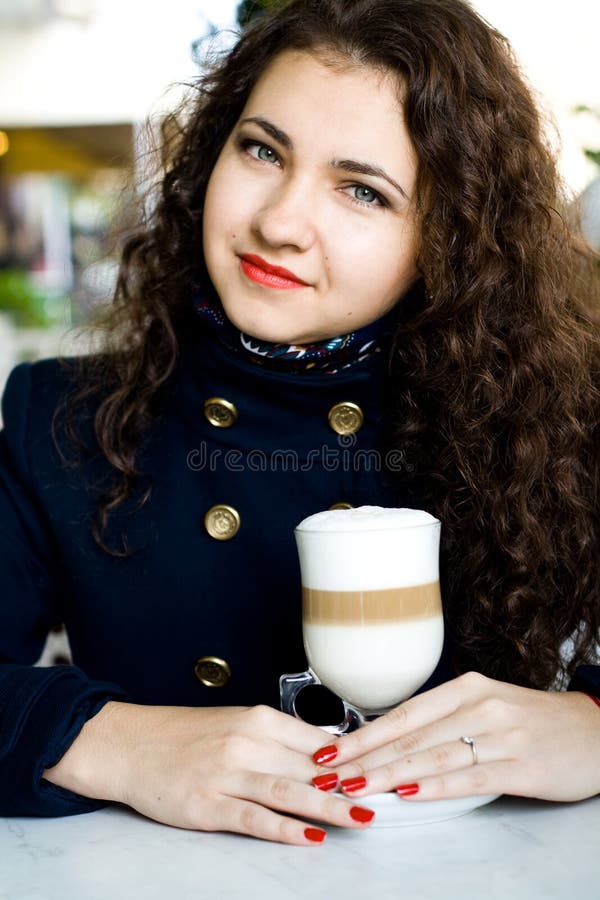 Young Beautiful Brunette with a Delicious Latte in a Cafe Stoc