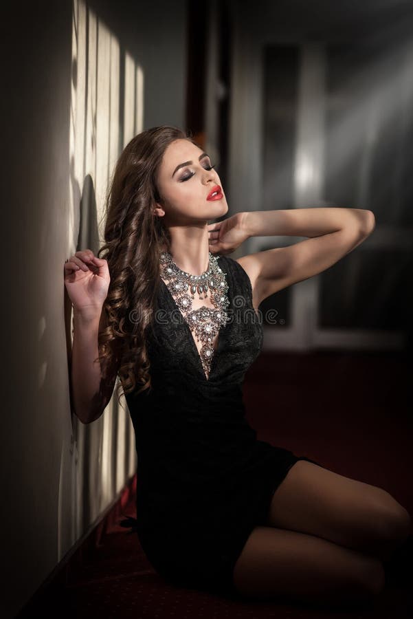 Woman in black long dress over dark background | Stock Photo ... Woman in black long dress over dark background | Stock Photo ...
