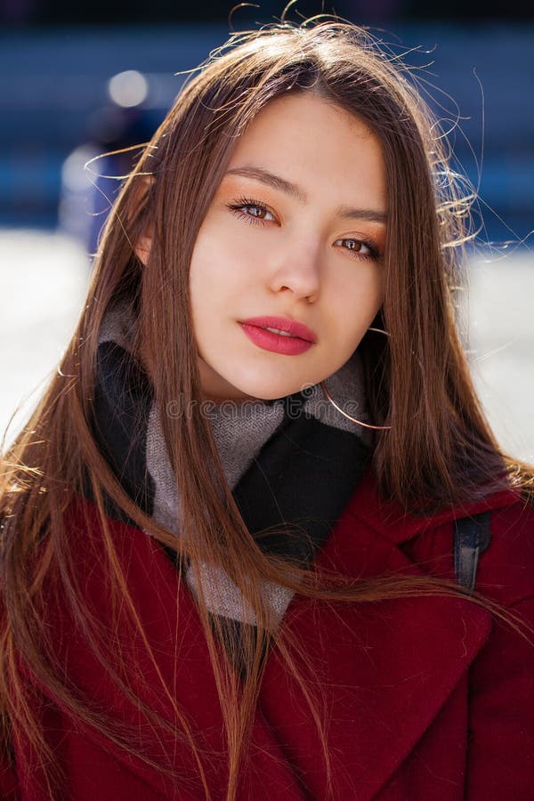 Young beautiful brunette woman in red coat posing on winter park royalty free stock image Young beautiful brunette woman in red coat posing on winter park royalty free stock image