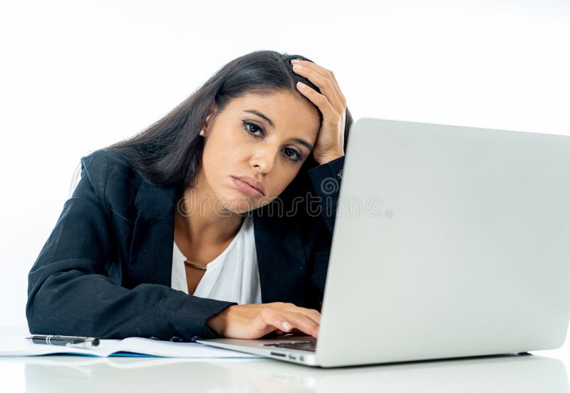 Young attractive businesswoman desperate and frustrated working on computer laptop at office in overtime and non fulfillment of ones hopes or professional expectations on white. Young attractive businesswoman desperate and frustrated working on computer laptop at office in overtime and non fulfillment of ones hopes or professional expectations on white