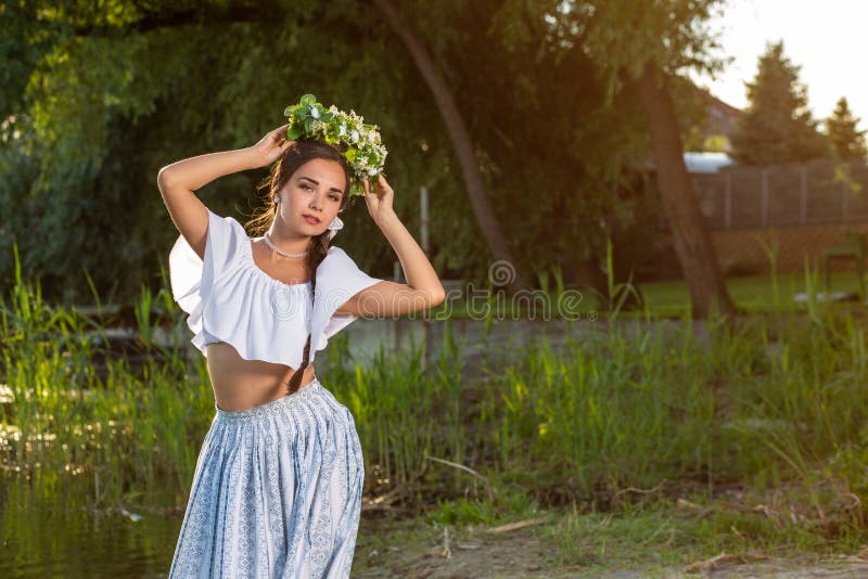 Young beautiful caucasian woman standing at the bank of river. Traditional countryside picture with girl at foreground royalty free stock image Young beautiful caucasian woman standing at the bank of river. Traditional countryside picture with girl at foreground royalty free stock image