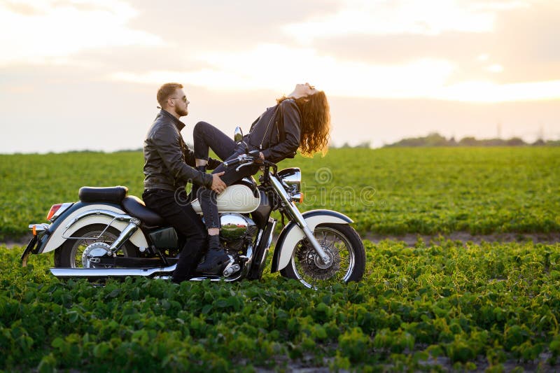 Free Photo | Lifestyle sunny portrait of young couple riders sitting  together on sand beach by motorbike - travel concept. two people and bike  .fashion woman and man hugging and smiling.