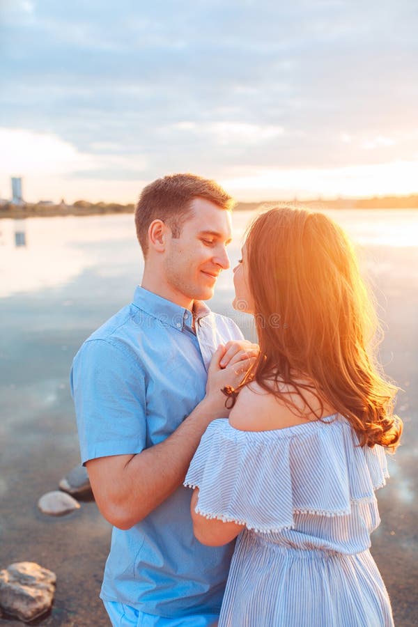 Young Beautiful Couple In Love Staying And Kissing On The Beach On