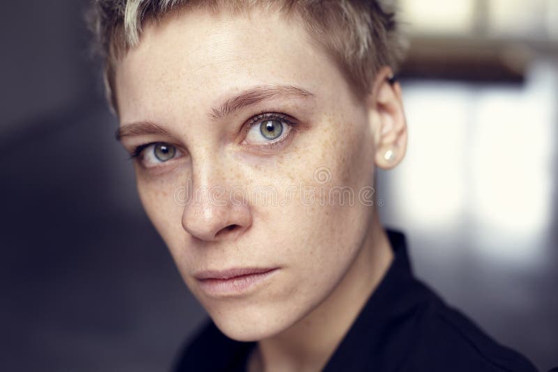 Young beautiful freckles woman face portrait with healthy skin and short hair, green eyes.