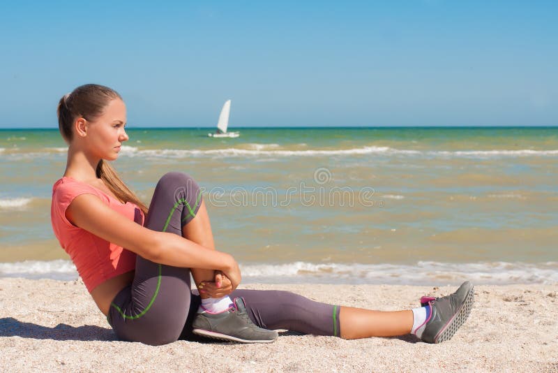 Young beautiful girl athlete playing sports on the beach