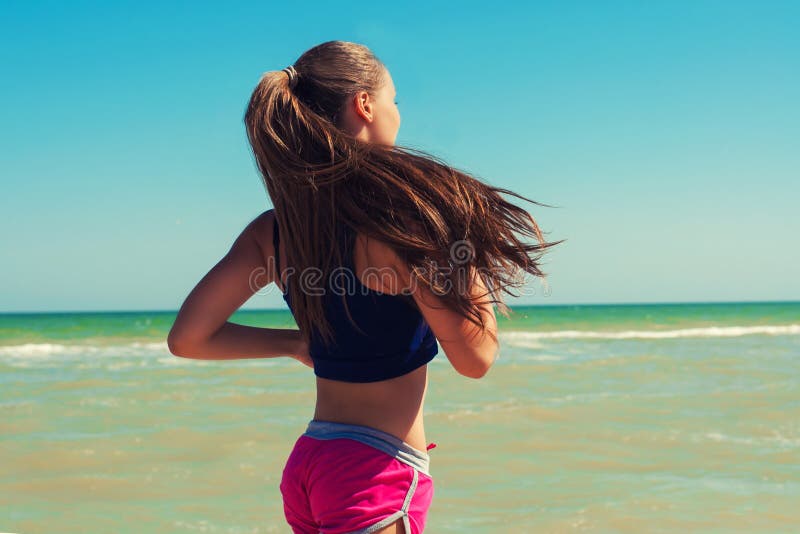 Young beautiful girl athlete playing sports on the beach