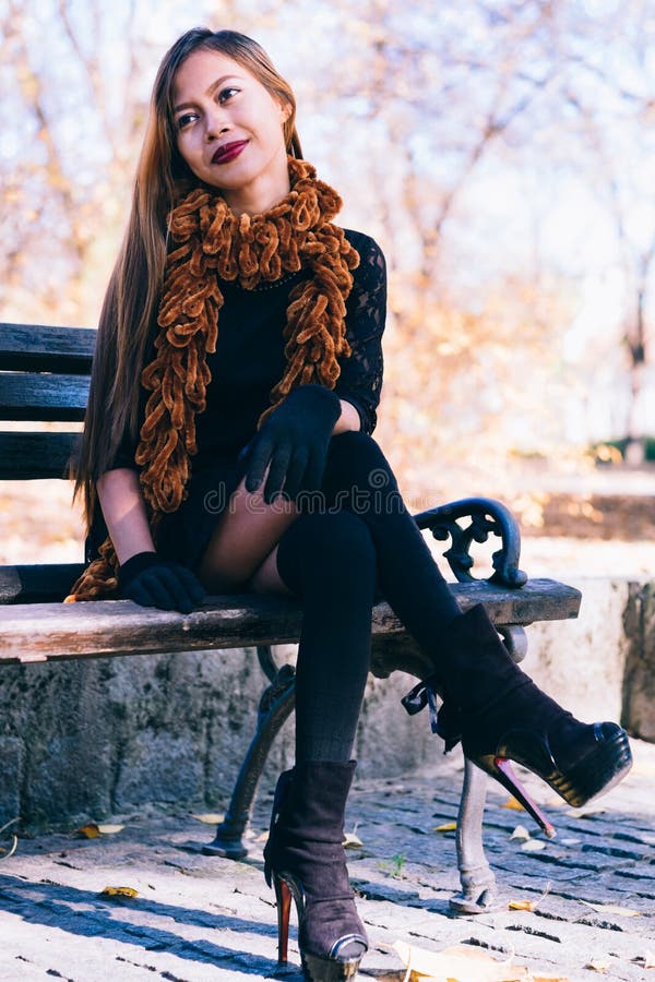 Young Beautiful Girl in Black Dress with Brown Scarf Sitting on the ...