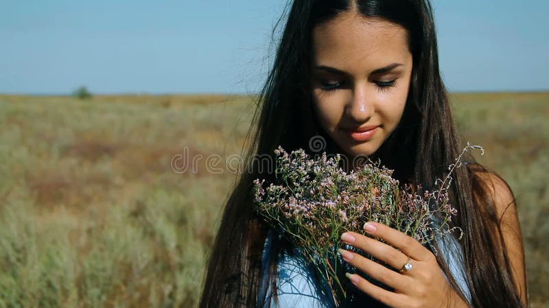 Young Beautiful Girl in a Blue Dress Enjoys Flowers Steppe. a Young Woman in a Meadow. Steppe. Blossoming Sunny Meadow Stock Video - Video of beautiful, freedom: 77307123