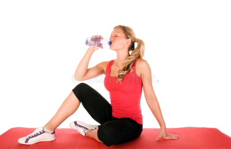 Young beautiful girl at the gym drinking water