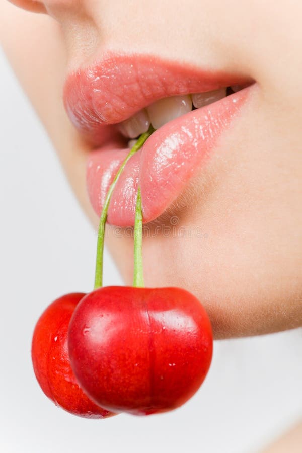 Young beautiful girl holding a cherry