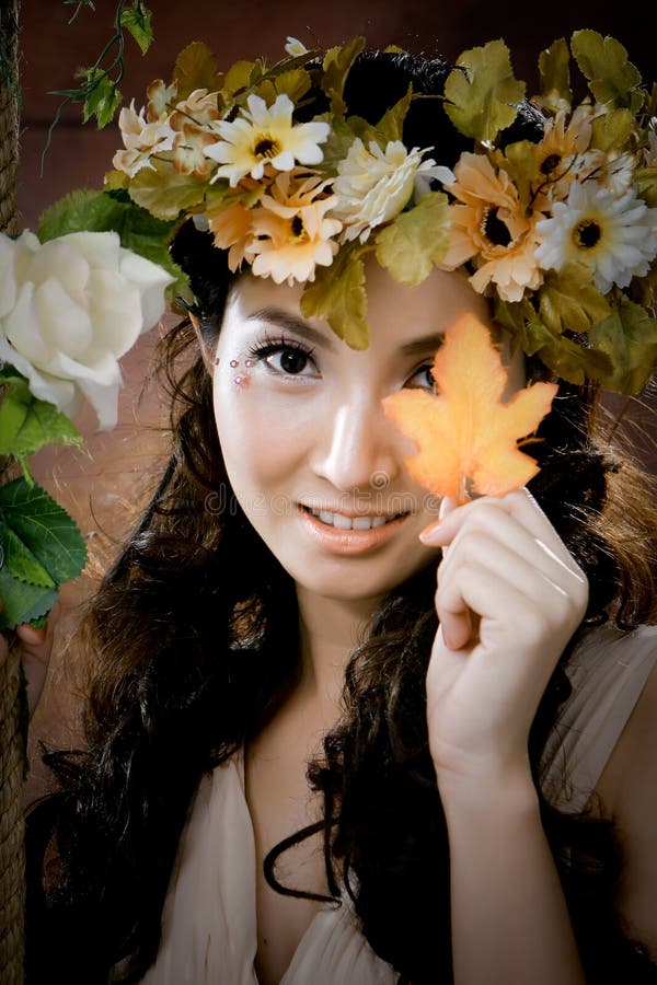 Young beautiful girl with maple leaf on her face