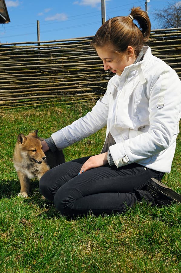 Young beautiful girl pets a puppy