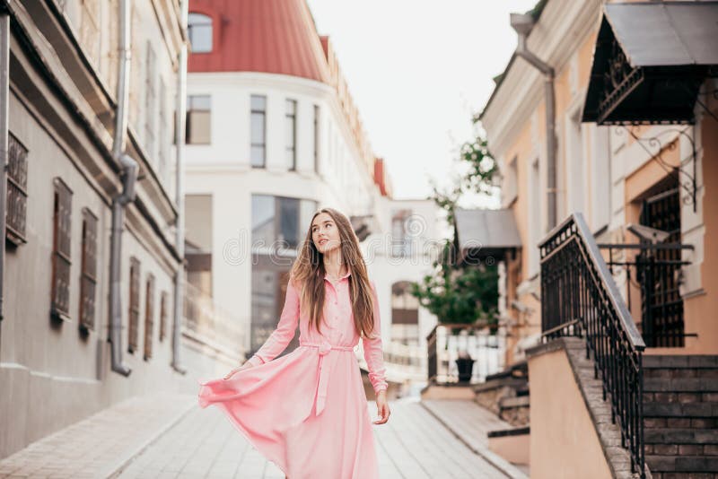 A Young, Beautiful Girl in a Pink Dress Walks through the Beautiful ...